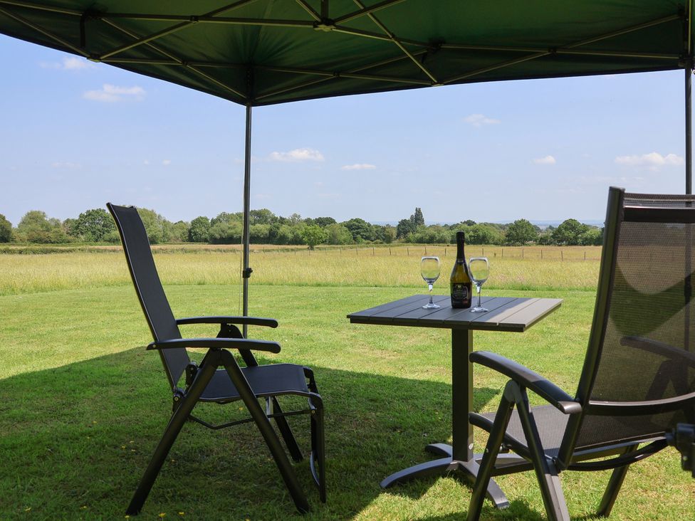 A seating area with a table and drinks under a tent at Honeypot Hideaways - Clover