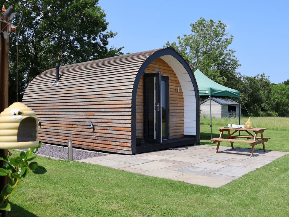 A cabin with a patio and a tent at Honeypot Hideaways - Clover