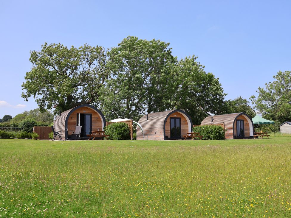 Three cabins with seating in an outdoor area at Honeypot Hideaways - Clover