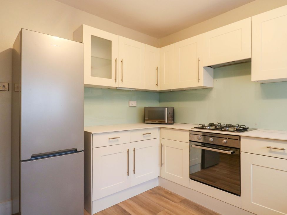 A kitchen with refrigerator microwave and gas stove at 13A Westgate Terrace in Whitstable