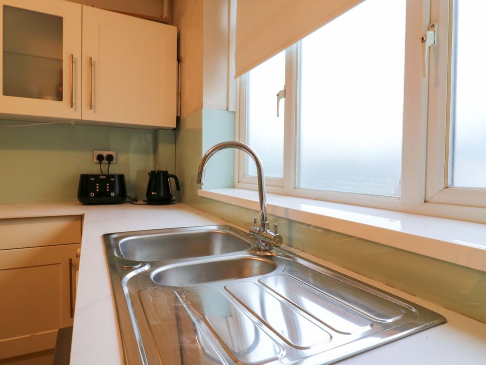 A kitchen with a sink and appliances at 13A Westgate Terrace in Whitstable