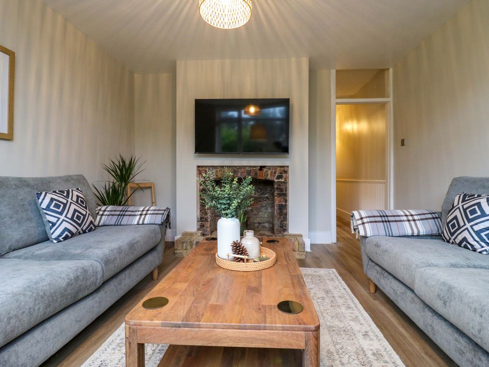 A living room with a fireplace and television at High Tide in Whitstable
