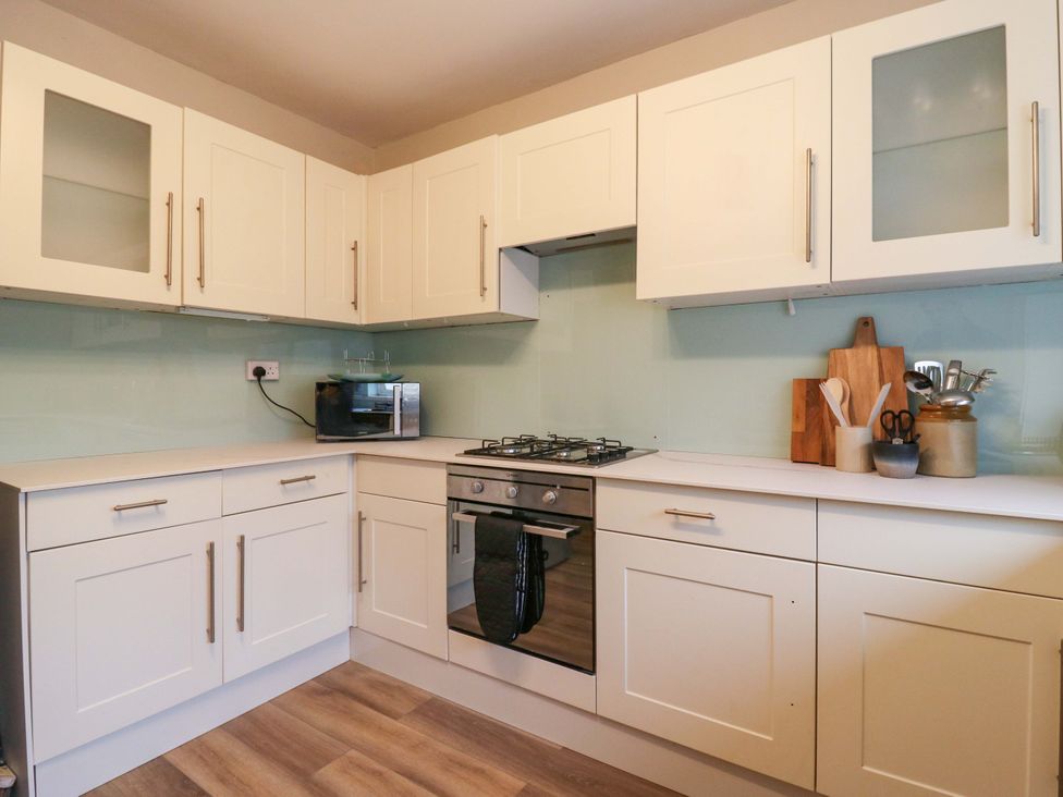 A kitchen with cabinets and a microwave at High Tide in Whitstable