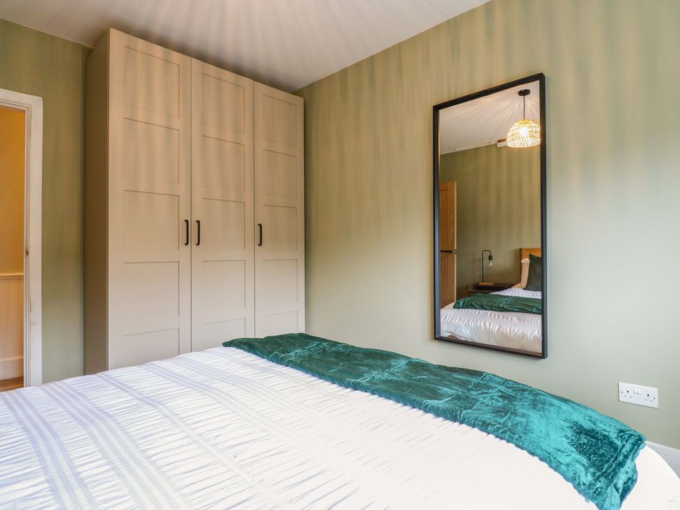 A bedroom with a bed and wardrobe at High Tide in Whitstable