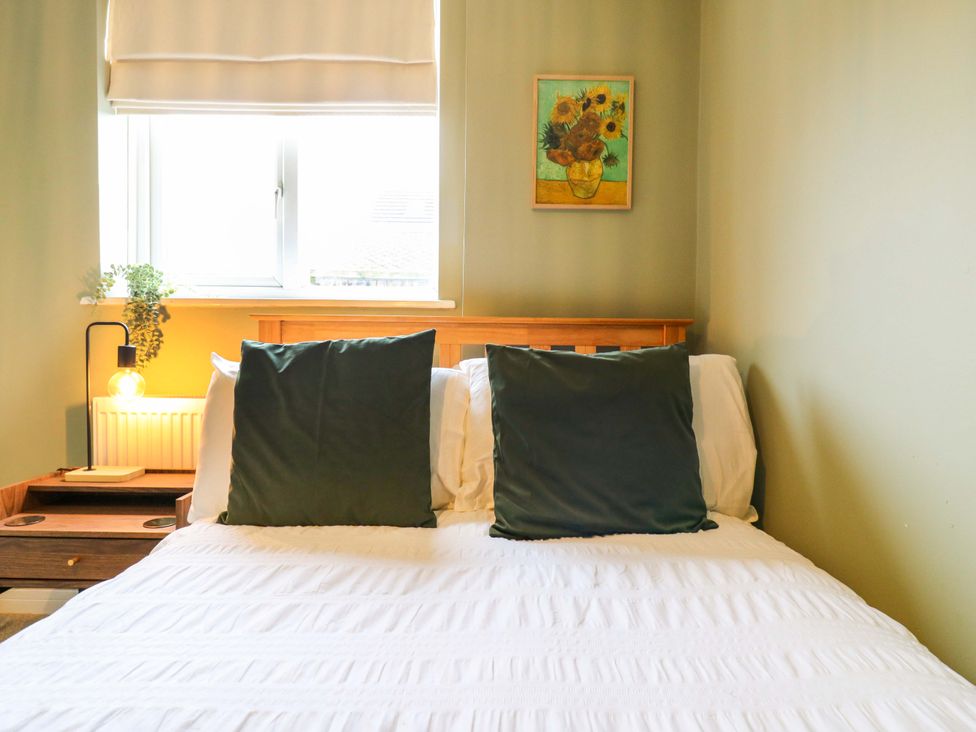 A bedroom with a bed and nightstand at High Tide in Whitstable