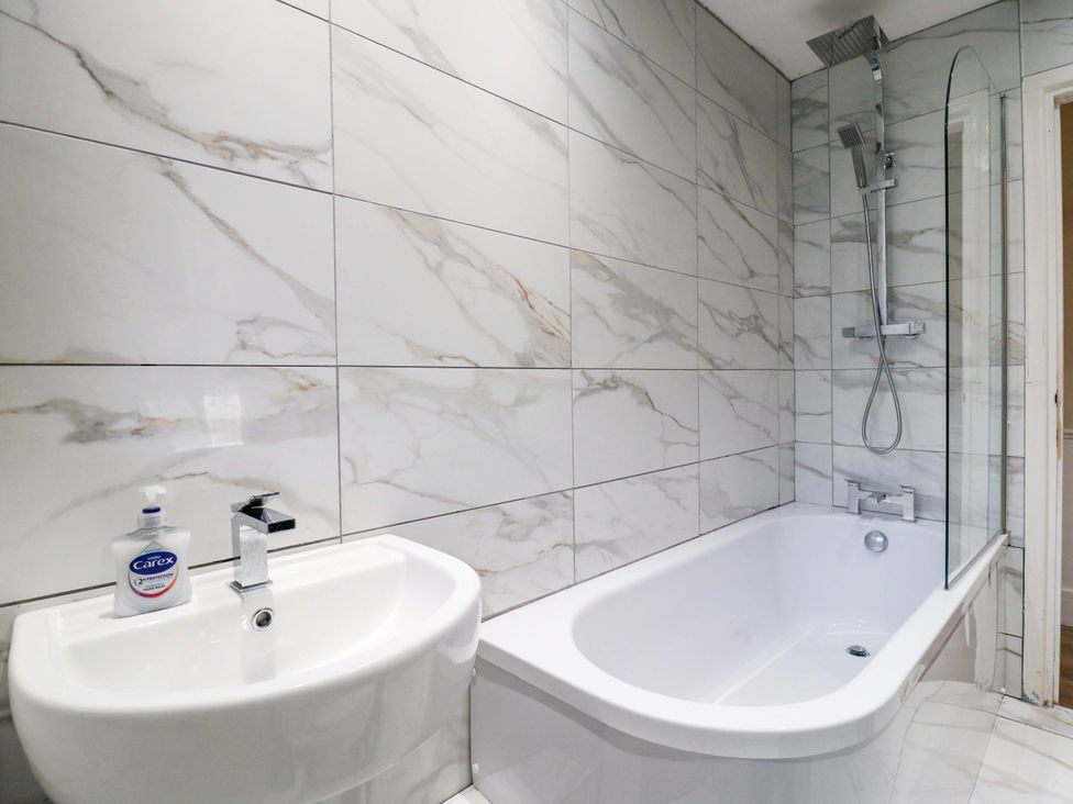 A bathroom featuring a bath tub and sink at High Tide in Whitstable