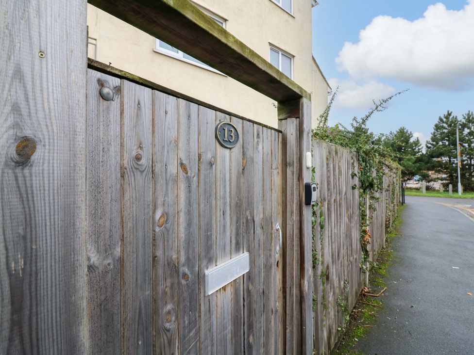 A wooden gate with number 13 and a letterbox at High Tide in Whitstable