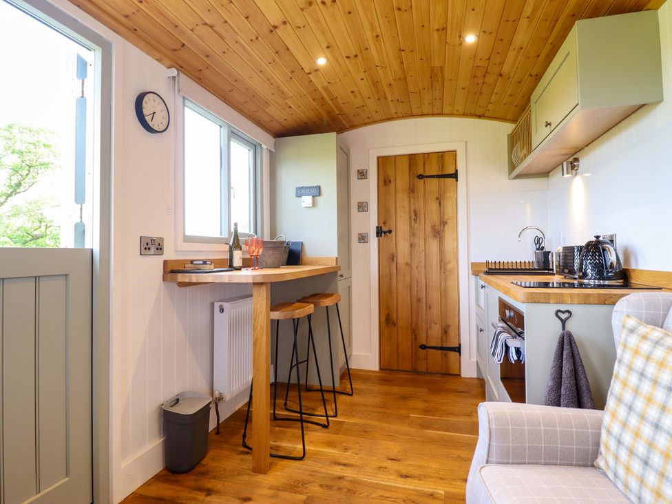 A kitchen with a bar table and stools at Charollais in Oswestry