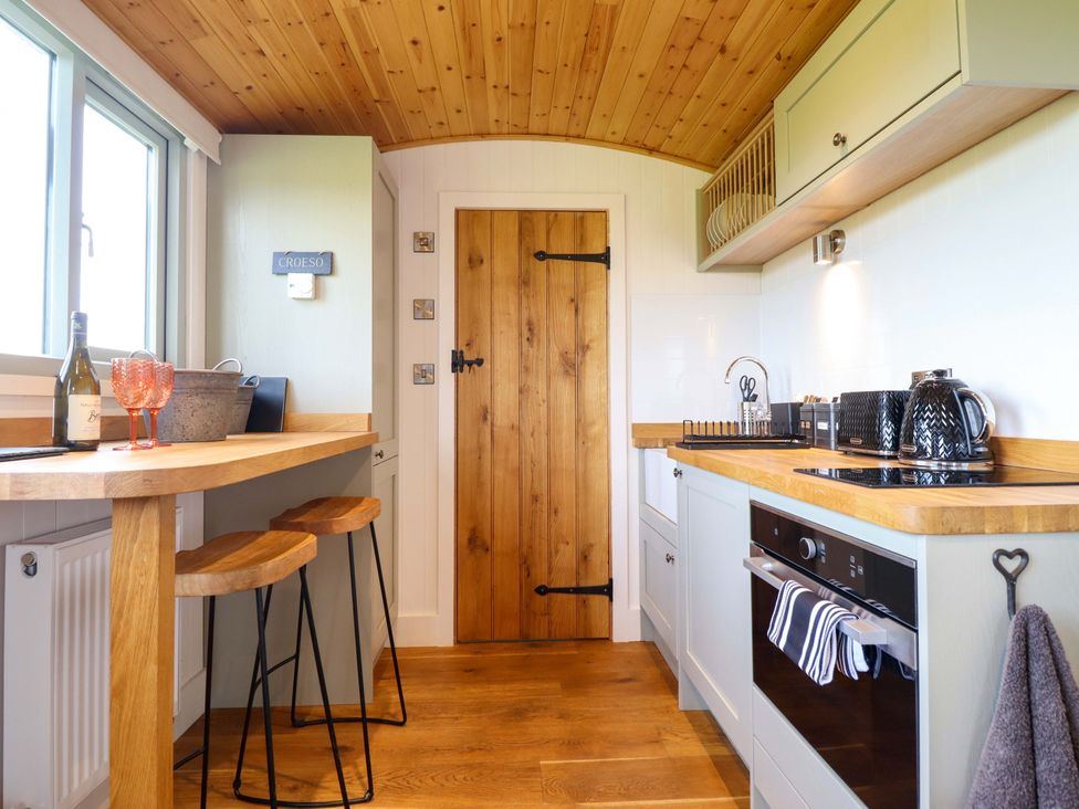 A kitchen with a countertop and stools at Charollais Oswestry
