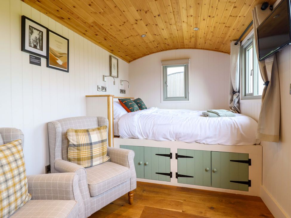 A bedroom with a bed and two chairs at Charollais in Oswestry