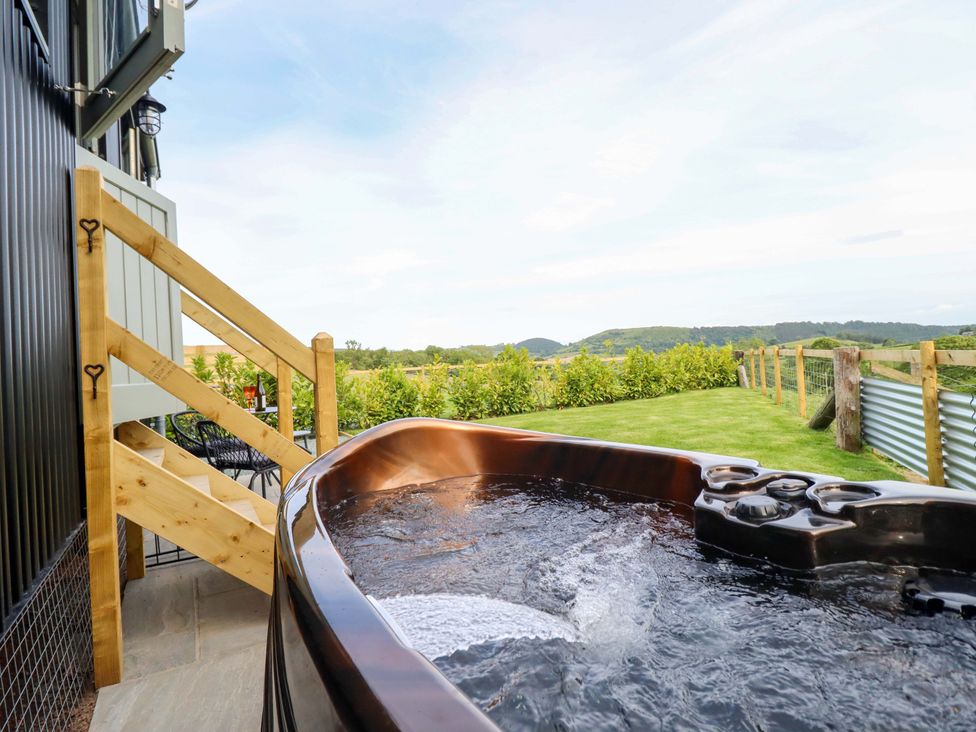 An outdoor area with a hot tub and stairs leading to a scenic view at Charollais in Oswestry