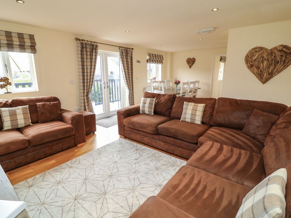 A living room with a sofa and dining area at Lodge 9 in Brigg