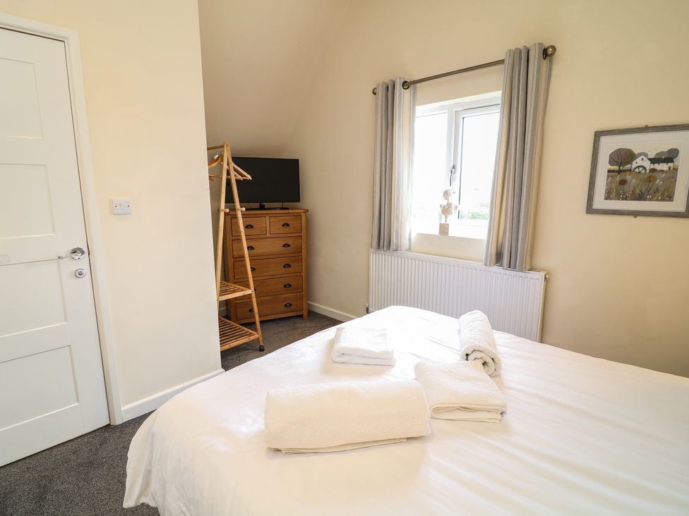 A bedroom with a bed and dresser at Lodge 9, Brigg