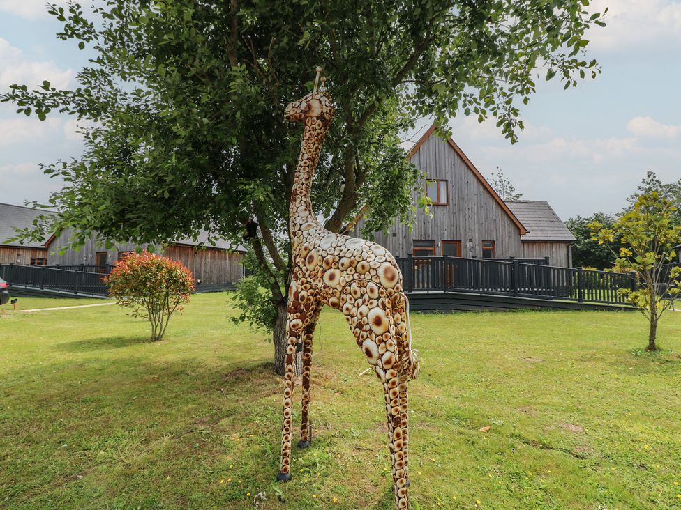 A giraffe statue near a tree at Lodge 9 in Brigg