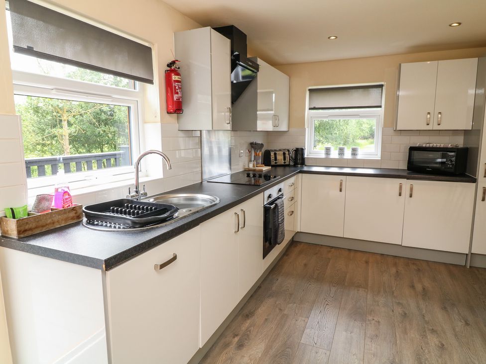 A kitchen with a sink, cabinets, and appliances at Lodge 13 in Brigg
