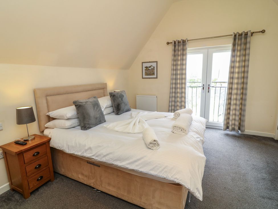 A bedroom with a bed and balcony doors at Lodge 13 in Brigg