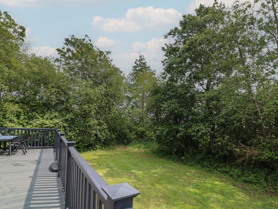 An outdoor area with a deck, table, and chairs at Lodge 13 in Brigg