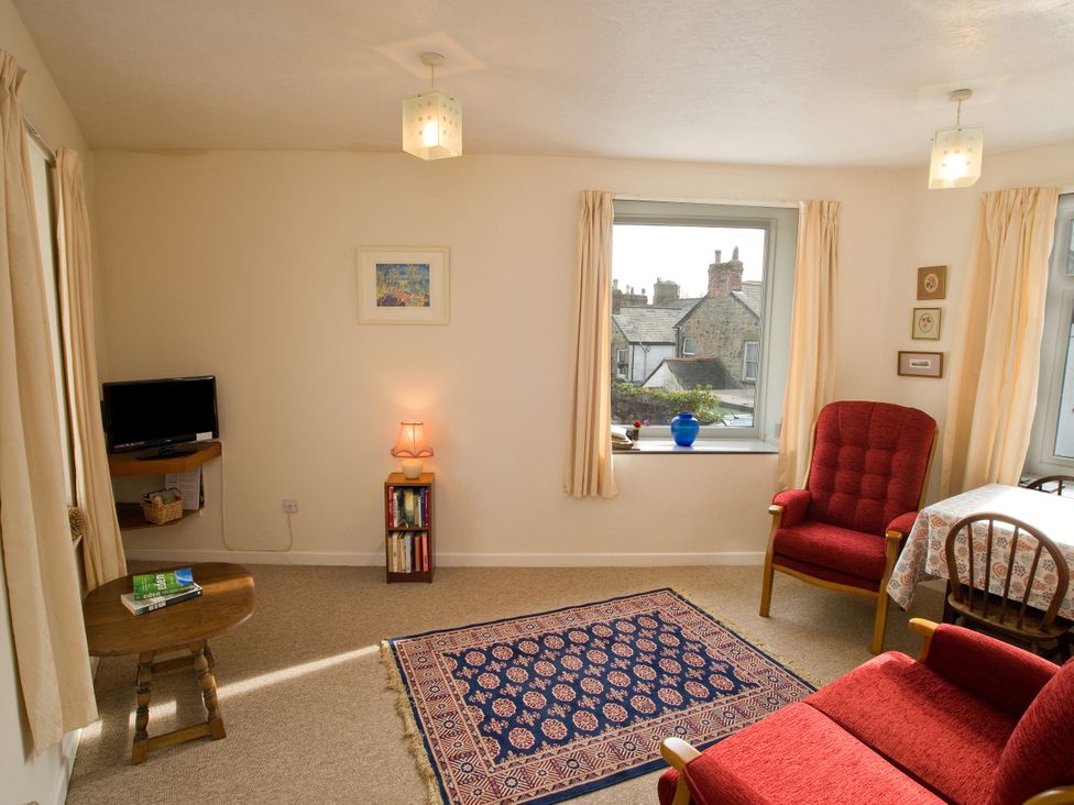 A living room with a television and books on a shelf at Chyancrowse Gulval