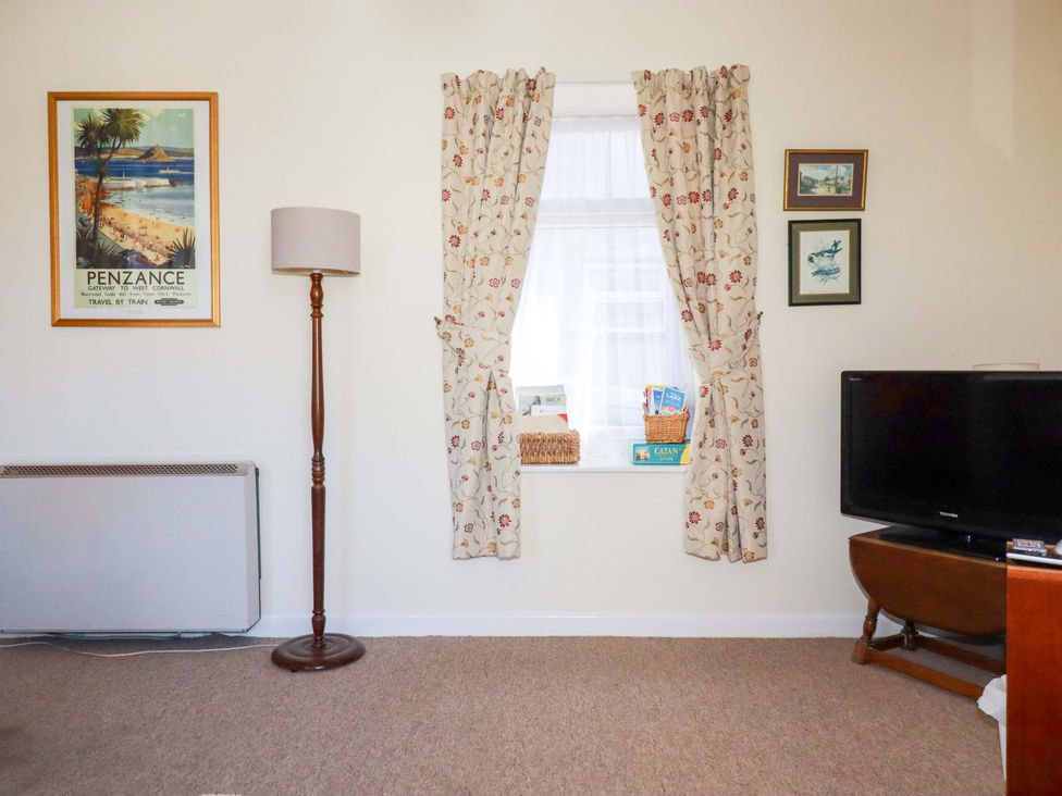A living room with a lamp, television, and window at Chyancrowse in Gulval