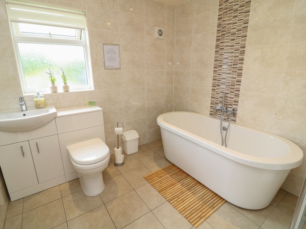 A bathroom with a bathtub, toilet, and sink at Lodge 14 in Brigg