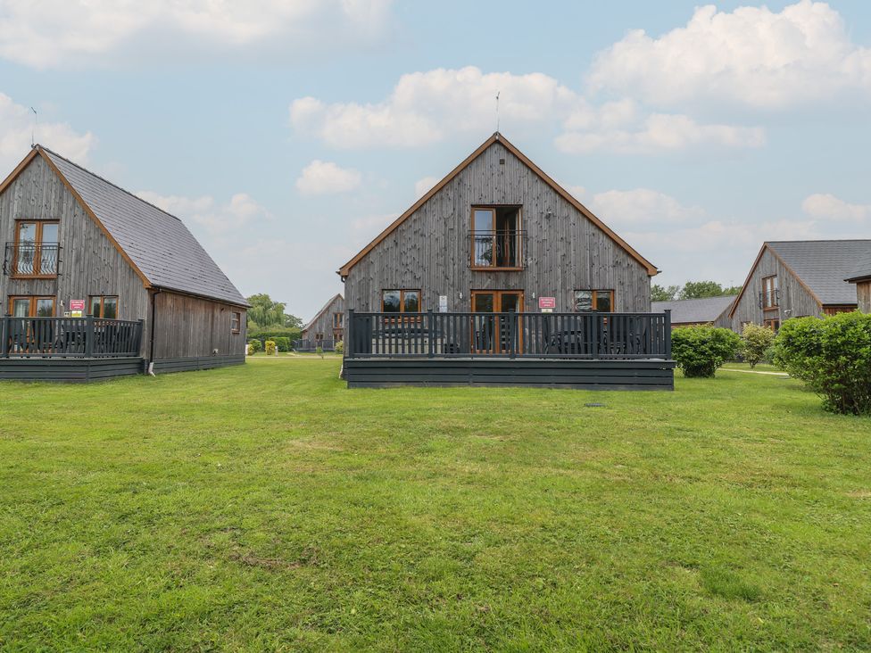 Three houses with balconies and grass area at Lodge 14 in Brigg