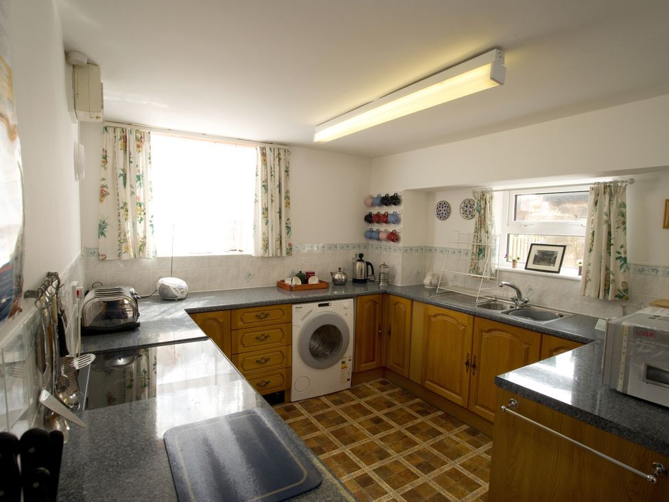 A kitchen with a washing machine and toaster at Chyandaunce in Gulval