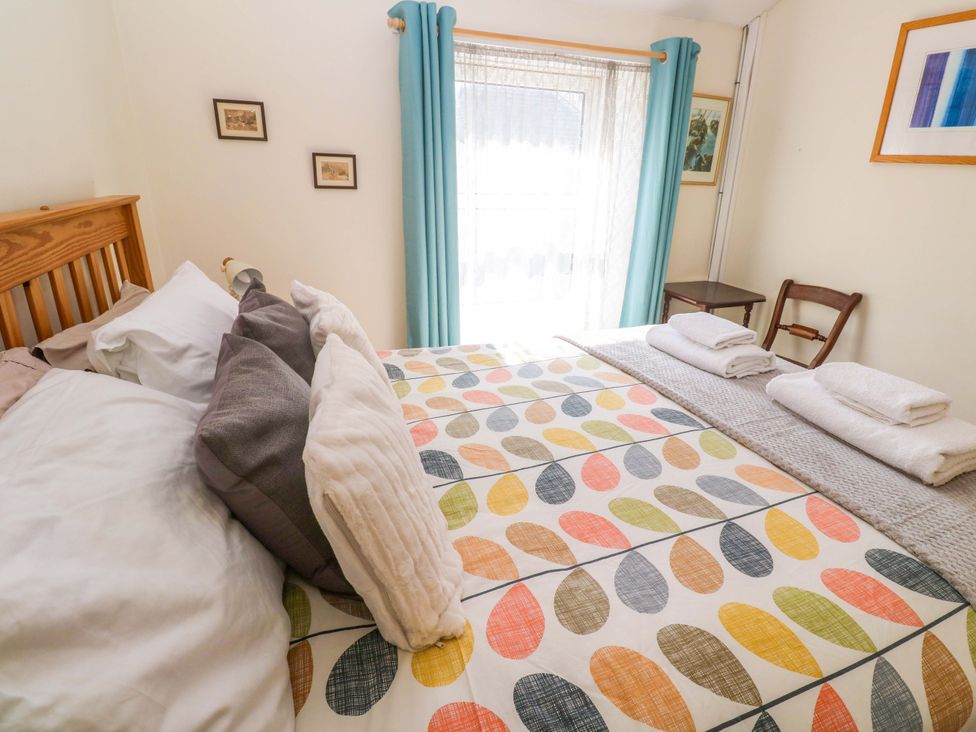 A bedroom with a bed and towels on a table at Chyandaunce in Gulval