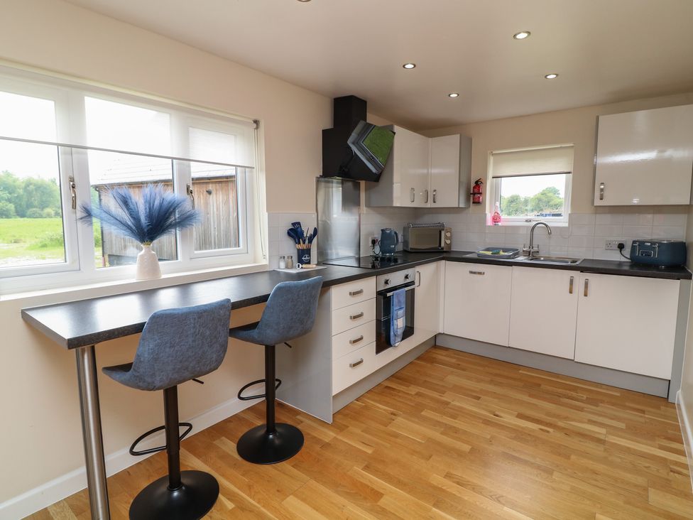 A kitchen with a table and stools at Lodge 21 Brigg