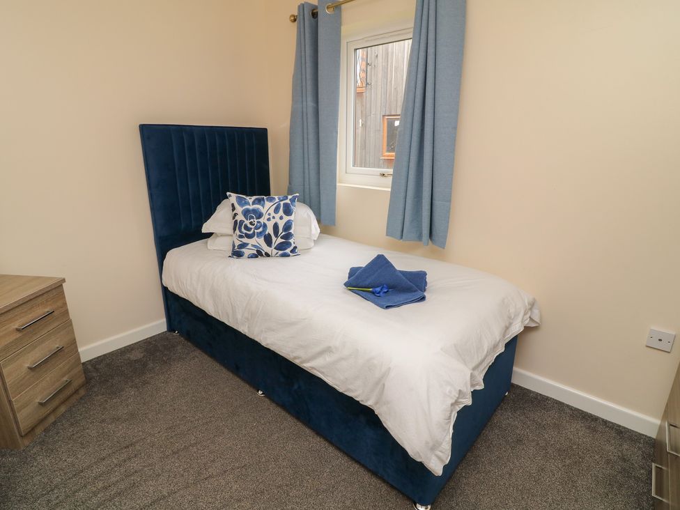 A bedroom with a single bed and curtains at Lodge 21 Brigg