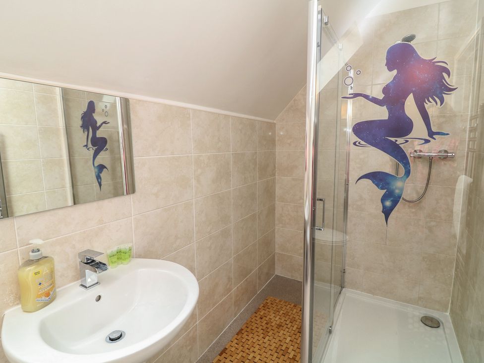 A bathroom with a sink, shower and mirror at Lodge 21 in Brigg