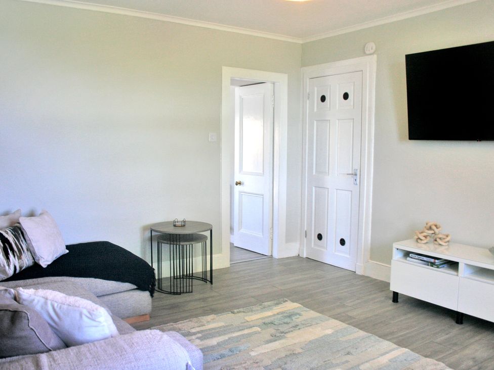 A living room with a sofa and coffee table at 2 Links Place in Nairn