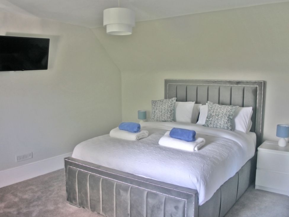 A bedroom with a bed and bedside lamps at 2 Links Place Nairn