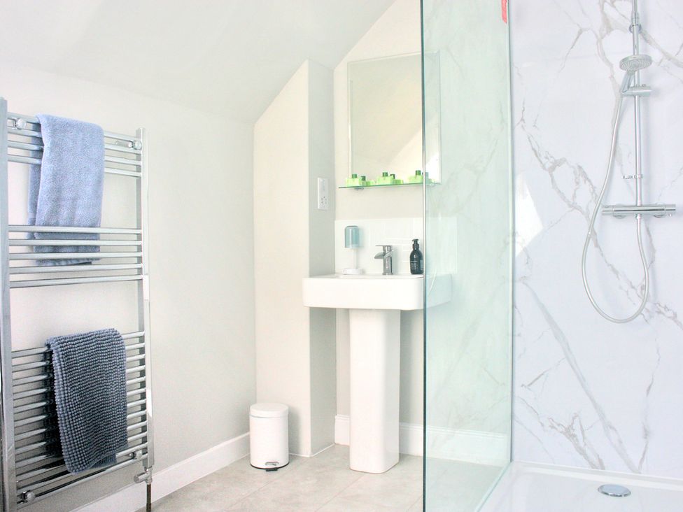 A bathroom with a sink and shower at 2 Links Place in Nairn