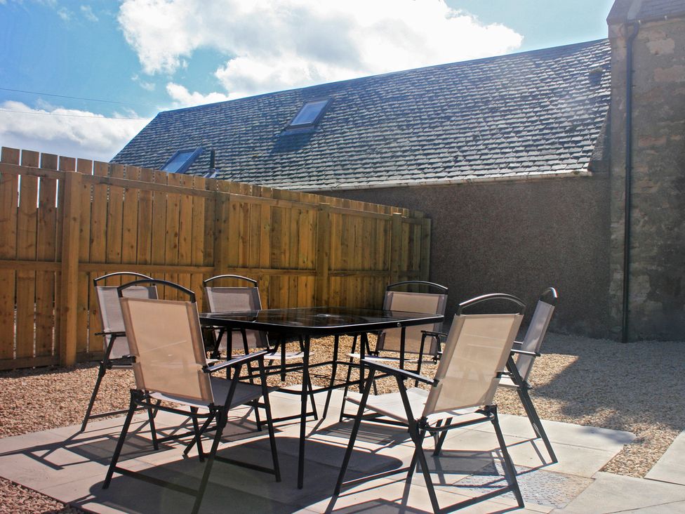 An outdoor area with a table and chairs at 2 Links Place in Nairn