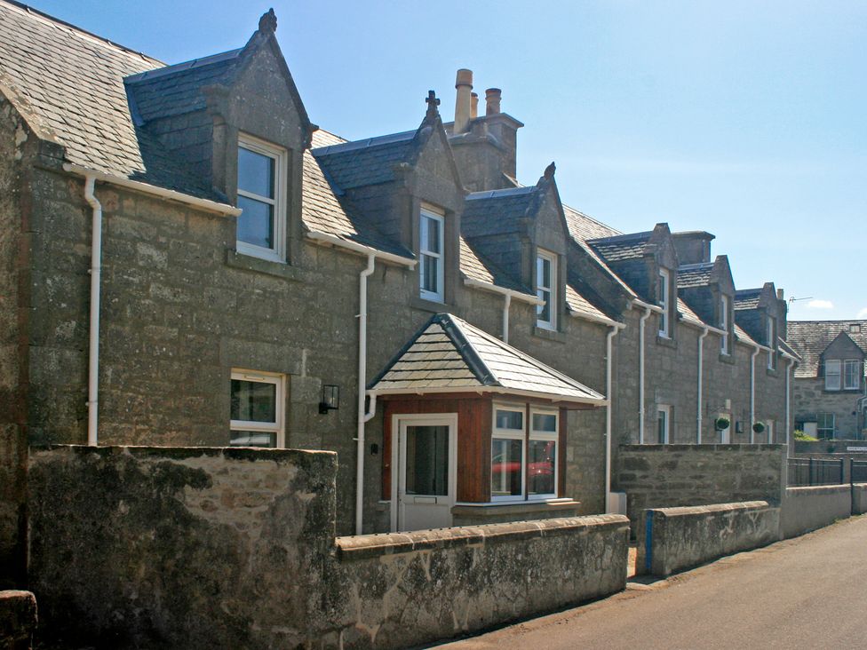 A row of houses with stone walls and pitched roofs at 2 Links Place Nairn
