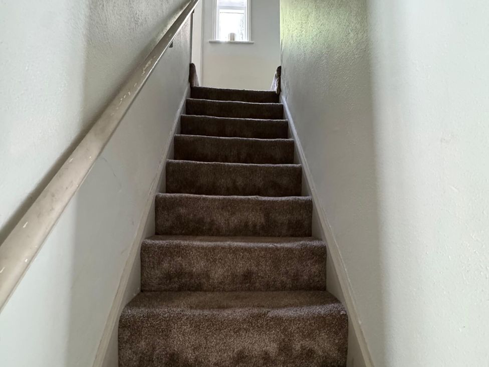 A staircase with a handrail and a window at 18 The Wharfage Ironbridge