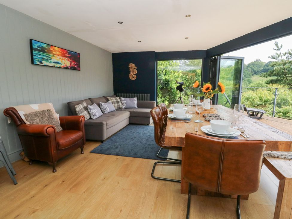 A living room with a sofa and dining table at The Old Barn in Ciliau Aeron near Aberaeron