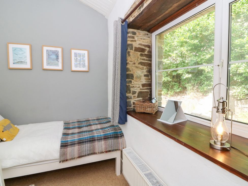A bedroom with a bed and window at The Old Barn in Ciliau Aeron near Aberaeron