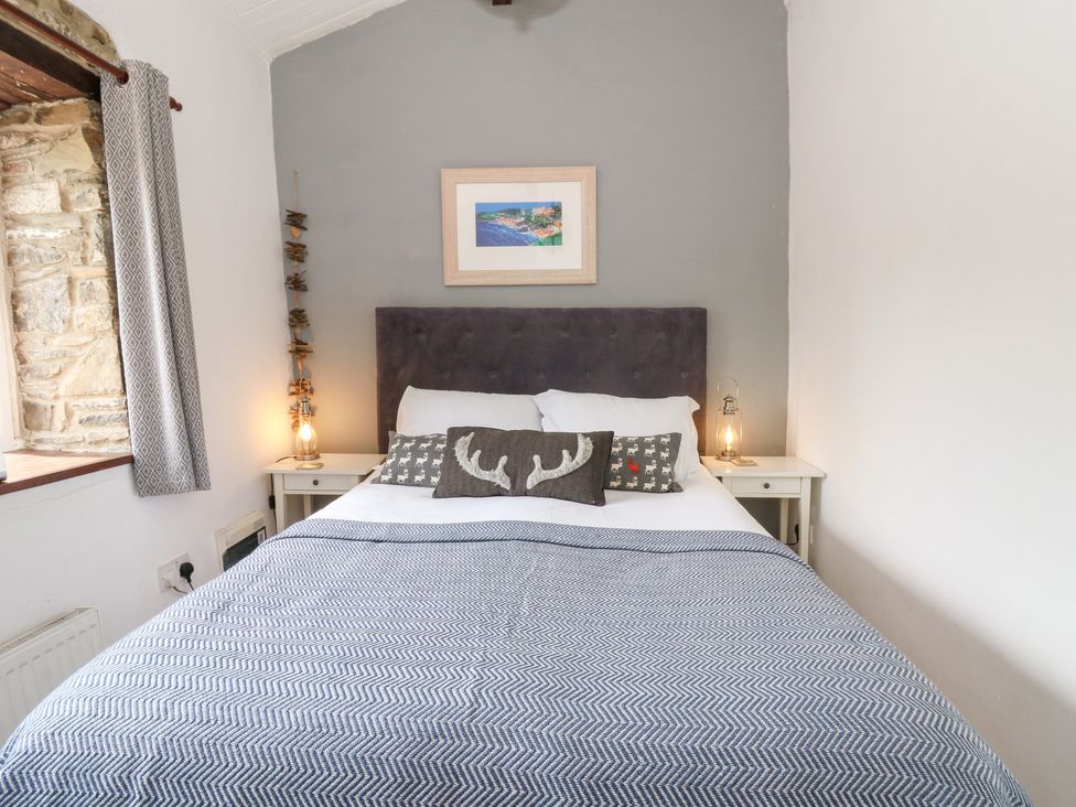 A bedroom with a bed and bedside table at The Old Barn in Ciliau Aeron near Aberaeron