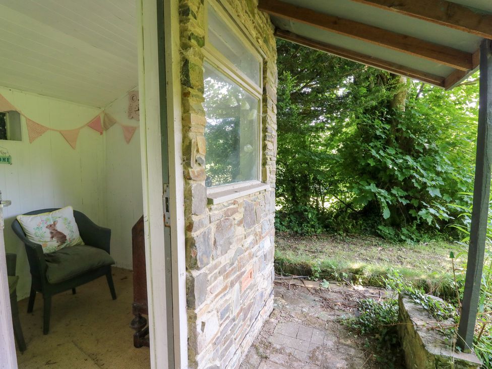 An outdoor area with a chair and plants at The Old Barn in Ciliau Aeron near Aberaeron