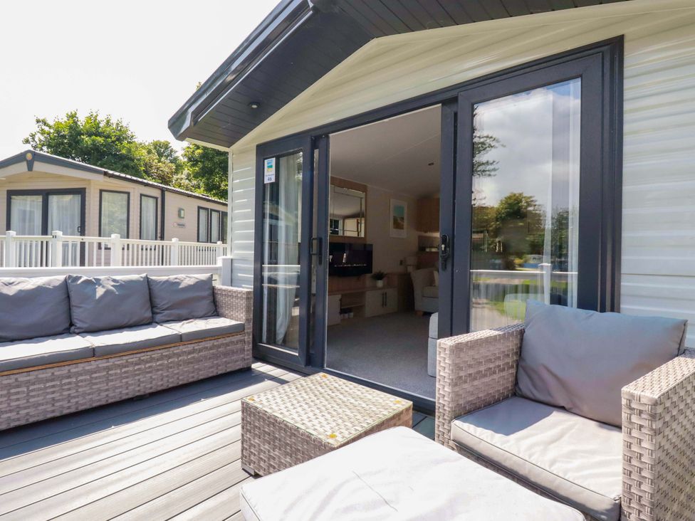 An outdoor patio area with a couch and table at Meadow 46 in Newquay