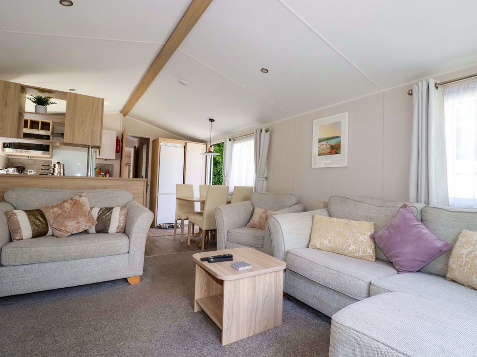 A living room with a sofa and dining area at Meadow 46 in Newquay