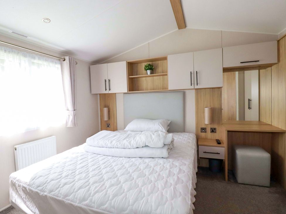 A bedroom with a bed and cabinet at Meadow 46 in Newquay