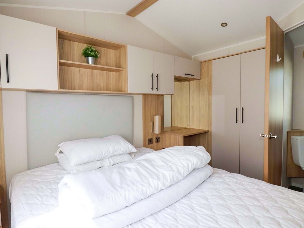 A bedroom with a bed and cabinets at Meadow 46 in Newquay
