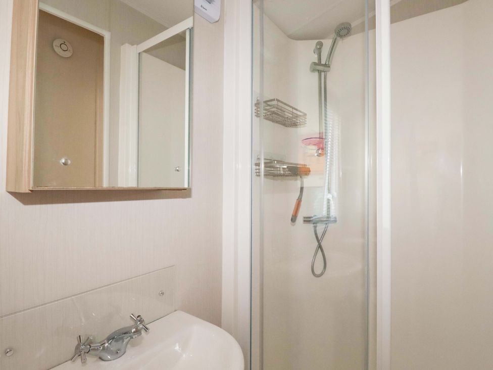 A bathroom with a shower and mirror at Meadow 46 in Newquay