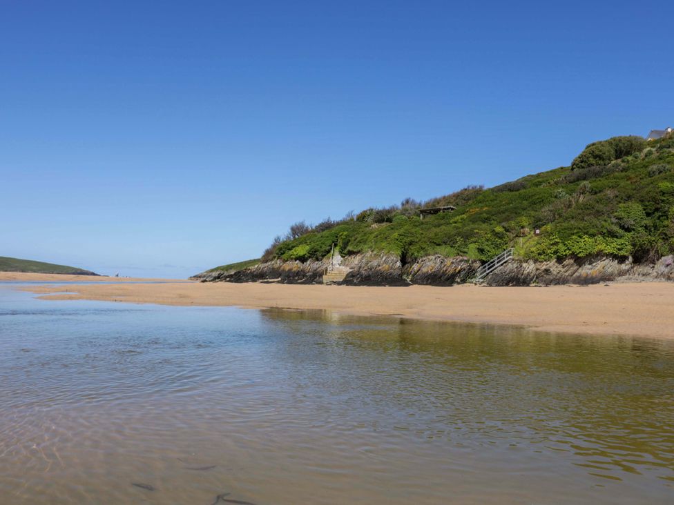 A beach with water and hills at Meadow 46 in Newquay