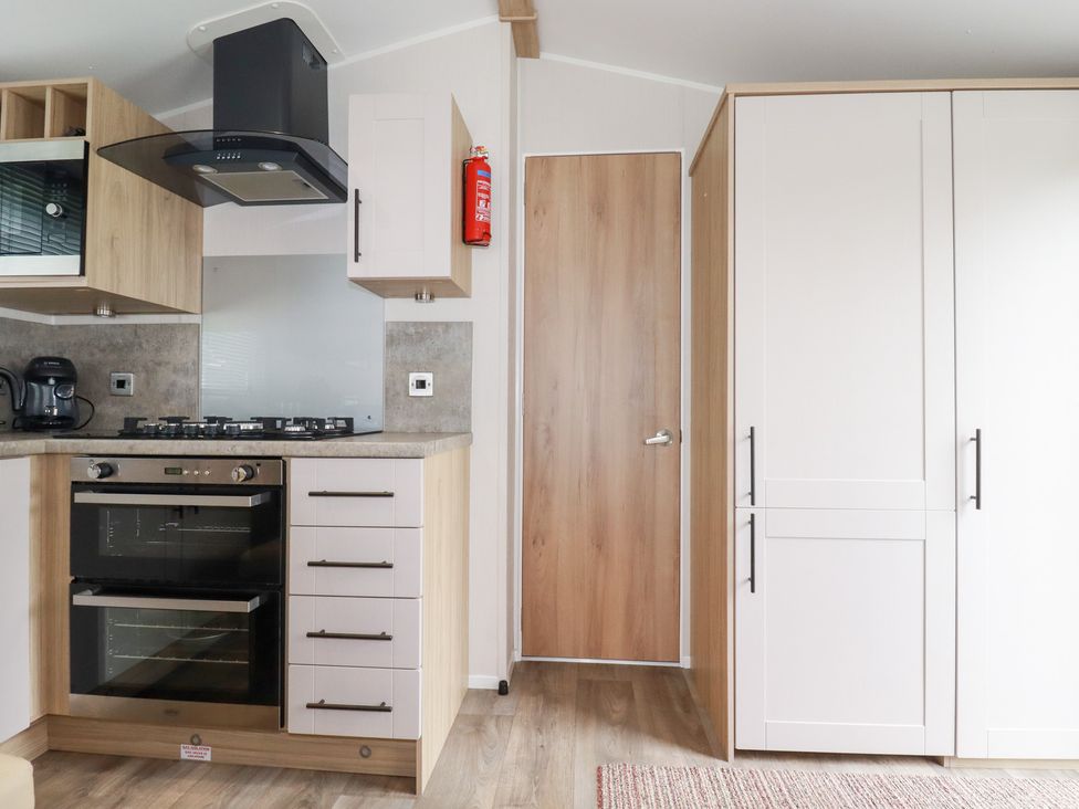 A kitchen with appliances and cabinets at Meadow 46 in Crantock