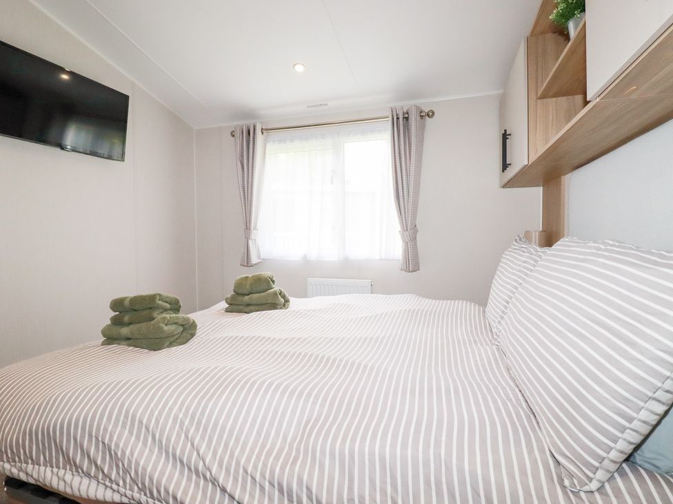 A bedroom with a bed and towels at Meadow 46 in Crantock