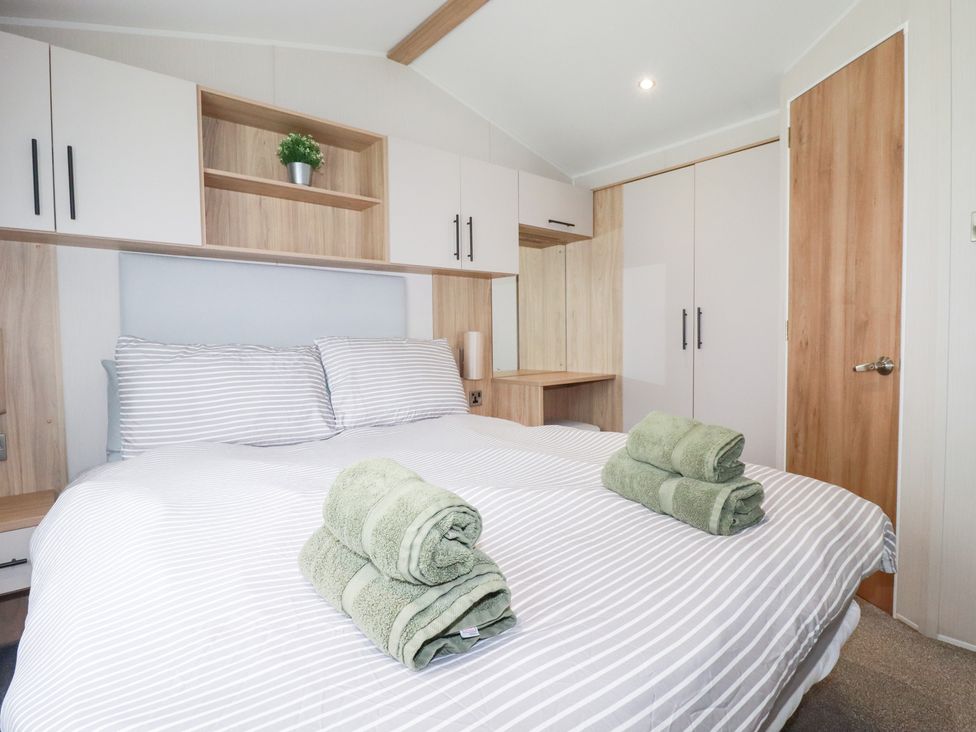 A bedroom with a bed and towels at Meadow 46 in Crantock
