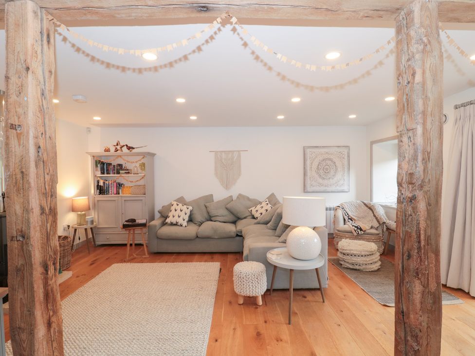 A living room with a sofa and a bookshelf at The Threshing Barn Chipping Norton